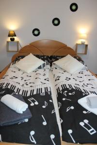 a bed with a black and white blanket and pillows at Villa LIKE "garden-grill" in Bardejov