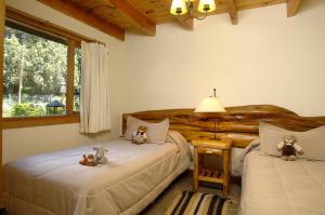 two beds in a bedroom with teddy bears on them at CABAÑAS VILLA LUCIA "UNº1 Virreyna" in San Carlos de Bariloche