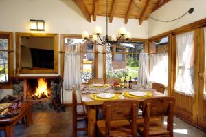 a dining room with a table and a fireplace at CABAÑAS VILLA LUCIA "UNº1 Virreyna" in San Carlos de Bariloche