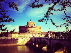 most nad rzeką z dużym budynkiem w obiekcie The Avalon w Rzymie