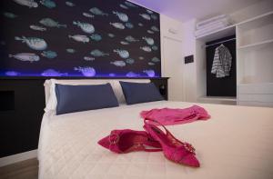 a bedroom with a bed with a dress and shoes on it at La Porta sulla spiaggia Casa vacanze in Su Forti