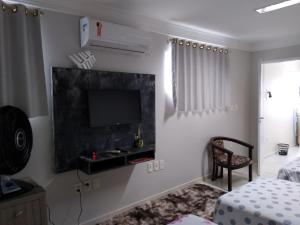 een slaapkamer met een tv aan de muur bij Apartamentos aconchegantes in Teresina