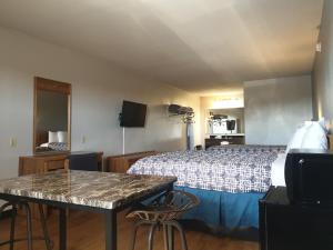 Riata Inn - Marfa في مارفا: غرفة فندقية بسرير وطاولة وكراسي