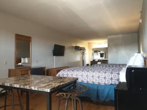 a hotel room with a bed and a table and chairs at Riata Inn - Marfa in Marfa