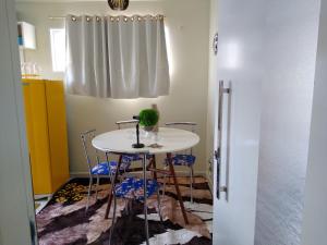 einen Tisch und Stühle in einer Küche mit Fenster in der Unterkunft Apartamentos aconchegantes in Teresina
