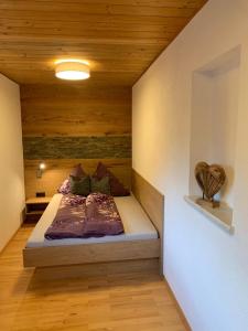 ランデックにあるFerienwohnung Tirolの木製の天井の客室で、ベッドルーム1室(ベッド1台付)