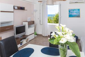 una sala de estar con un jarrón de flores sobre una mesa en Apartments Krmek, en Dubrovnik