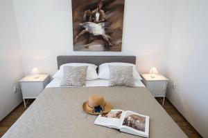 una cama con sombrero y un libro sobre ella en Apartments Krmek, en Dubrovnik