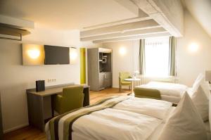 ein Hotelzimmer mit 2 Betten und einem TV in der Unterkunft Hotel am Schloss in Heidelberg