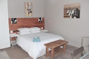 Un dormitorio con una cama con una toalla azul. en GlassTree B&B, en Bredasdorp