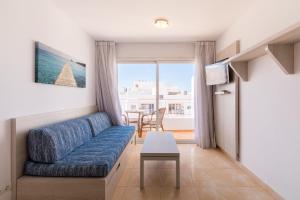 a living room with a couch and a table at Apartamentos Avenida - MC Apartamentos Ibiza in Ibiza Town