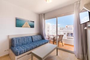 a living room filled with furniture and a window at Apartamentos Avenida - MC Apartamentos Ibiza in Ibiza Town