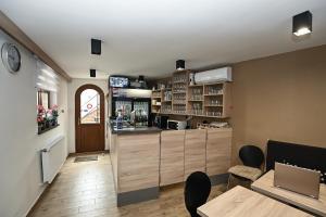 a kitchen with a counter and a bar with chairs at Vaskó Panzió Borpince in Tokaj