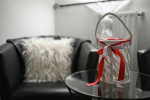 a glass table in front of a couch with a chair at Vask&oacute; Panzi&oacute; Borpince in Tokaj