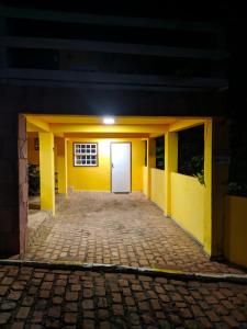 a yellow building with a white door at night at Pousada das Arvores in Lençóis