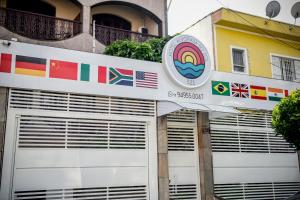 a building with garage doors with flags on it at Hotel Alvorada do Sol in Sao Paulo