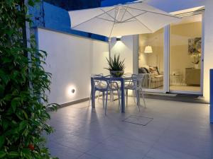 a table and chairs with an umbrella on a patio at Villa Luminosa in Torre del Lago Puccini