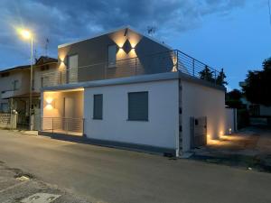 a white house with a balcony on top of it at Villa Luminosa in Torre del Lago Puccini