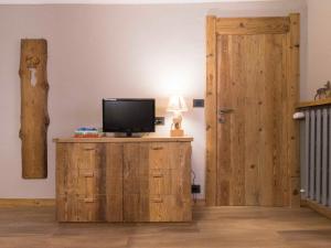 バルドネッキアにあるCasaborgovecchio Lariceのテレビ付きの客室で、木製のキャビネットにドアがあります。