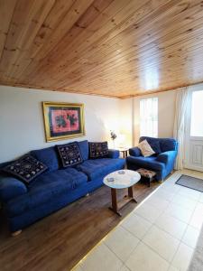 a living room with a blue couch and a table at The Nook @ Rowan Tree Cottage in Ballymoney