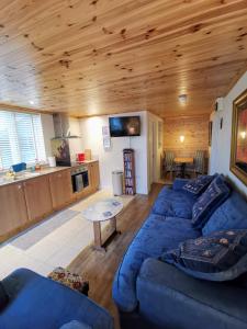 a living room with blue couches and a kitchen at The Nook @ Rowan Tree Cottage in Ballymoney +36 photos