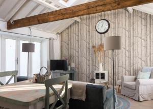 a room with a table and a clock on the wall at Crafts Hill Barn in Cambridge