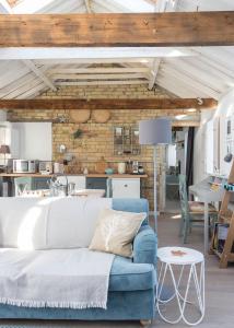 ein Wohnzimmer mit einem blauen Sofa und einer Ziegelwand in der Unterkunft Crafts Hill Barn in Cambridge