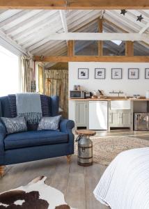 a living room with a blue couch and a kitchen at Crafts Hill Barn in Cambridge
