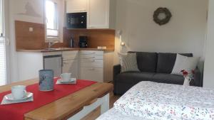 Una cocina y una sala de estar con un sofá y una mesa. en Appartement An der Radau, en Bad Harzburg