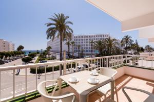 balcón con mesa, sillas y vistas a la ciudad en Apartamentos Vistamar I - MC Apartamentos Ibiza en Playa d'en Bossa