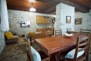 a kitchen and dining room with a wooden table at Seaside Duplex Stone Villa in Qeparo