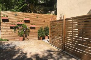 a wooden fence with potted plants on it at Appartement au calme dans un espace arboré in Tourrettes-sur-Loup