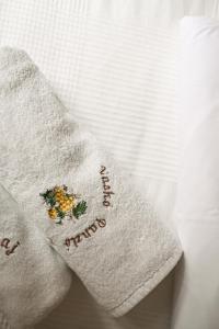 a white towel with flowers on it on a bed at Vaskó Panzió Borpince in Tokaj +70 photos