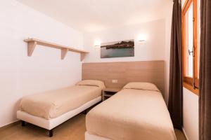 a room with two beds and a window at Apartamentos Malacosta - MC Apartamentos Ibiza in Playa d'en Bossa