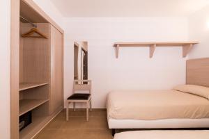 イビサ・タウンにあるApartamentos Malacosta - MC Apartamentos Ibizaの小さなベッドルーム(ベッド1台、椅子付)
