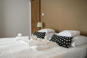 1 cama blanca con almohadas blancas y una cuña en Vaskó Panzió Borpince, en Tokaj