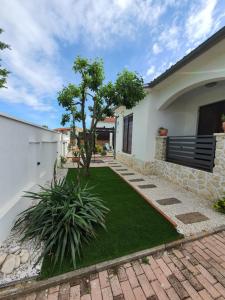 dom z trawnikiem przed nim w obiekcie HOLIDAY HOME "MARIJANA" w mieście Ližnjan