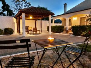 a candle on a wooden table in front of a house at Villa Elena - Private Villa in the heart of nature in Chania Town