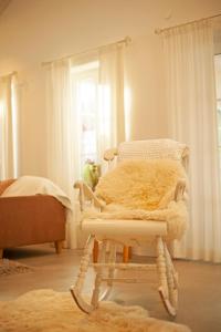 a white rocking chair with a furry seat in a room at Blomstertantens Hus in Trelleborg