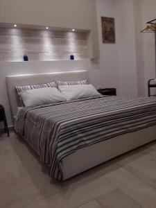 瑪格麗塔薩沃亞的住宿－Maison Marguerite，一间卧室配有一张带条纹毯子的大床