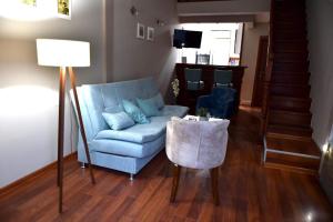 - un salon avec un canapé bleu et une table dans l'établissement Apartman Royal, à Gornji Milanovac