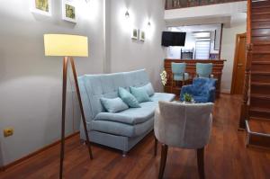 sala de estar con sofá azul y silla en Apartman Royal en Gornji Milanovac