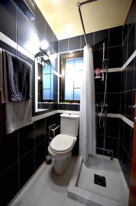 Baño negro con aseo y ducha en Apartman Royal en Gornji Milanovac