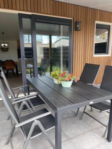 a wooden table with two potted plants on a patio at Wad Mooi in Tzummarum