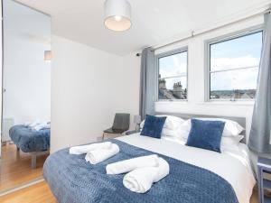 ein Schlafzimmer mit einem großen Bett mit blauen und weißen Kissen in der Unterkunft Pass the Keys Bright modern one bed apartment - Bath city centre in Bath