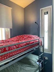 a bedroom with a bunk bed with a red blanket at Wad Mooi in Tzummarum +11 photos