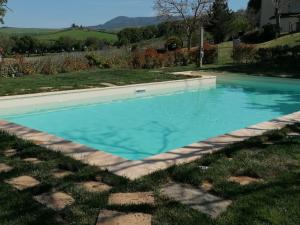 uma piscina num quintal com água azul em Agriturismo La Poderina em Bagno Vignoni
