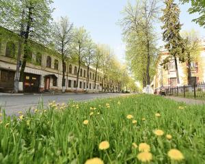 uma rua com um campo de relva e flores em Гостиница City House em Yaroslavl