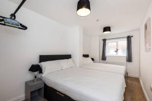 een slaapkamer met 2 witte bedden en een raam bij Liverpool City Centre - Fabulous 3 En-suite Bedrooms - Sleeps 10 People in Liverpool