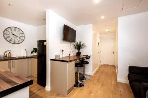 a kitchen with a counter and a clock on the wall at Liverpool City Centre - Fabulous 3 En-suite Bedrooms - Sleeps 10 People in Liverpool